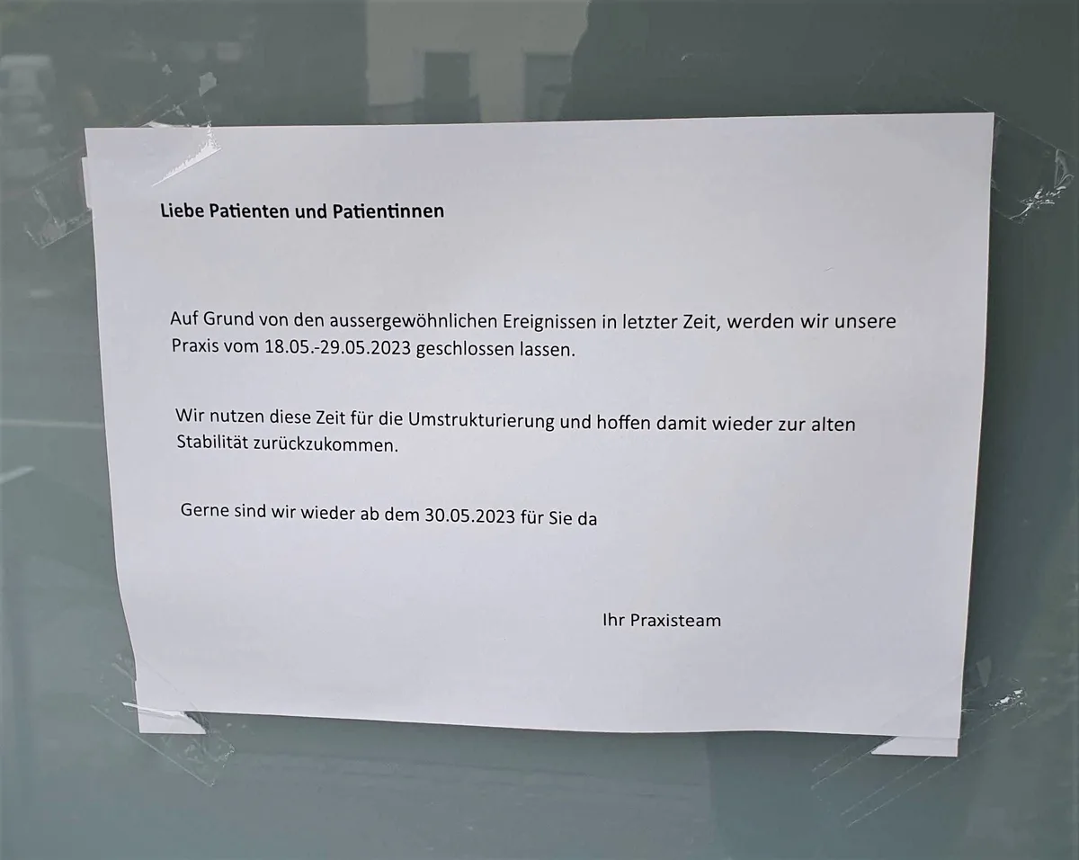 Man sieht ein mit Klebestreifen befestigtes A4-Blatt an einer Tür.